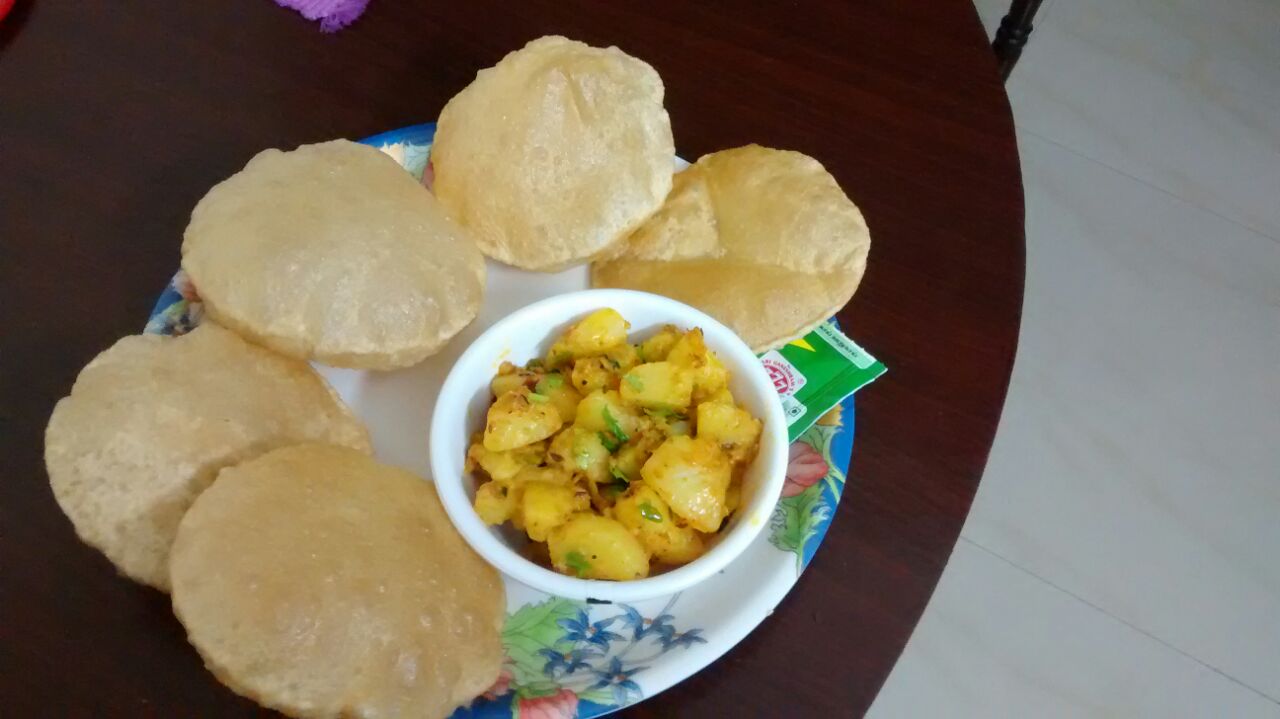 Dry aloo/potato with 5 pooris and a bowl of garlic flavoured curds